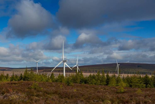 Four wind turbines at Clashindarroch wind farm set against a cloudy sky